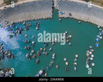 Vue aérienne du village de pêcheurs de Loc an, ville de Vung Tau. Un port de pêche avec des blocs de béton de protection contre les tsunamis. Paysage urbain et bateaux traditionnels dans le s. Banque D'Images