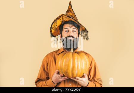Jeune homme avec chapeau de sorcière prêt à Halloween partie. Homme d'Halloween barbu dans un chapeau de sorcière - prise de vue en gros plan en studio. La cuisine de Thanksgiving. Banque D'Images
