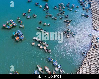 Vue aérienne du village de pêcheurs de Loc an, ville de Vung Tau. Un port de pêche avec des blocs de béton de protection contre les tsunamis. Paysage urbain et bateaux traditionnels dans le s. Banque D'Images