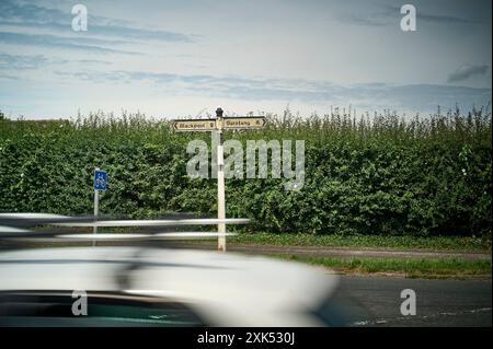 Trafic sur la route A585 entre Blackpool et Garstang avec poste de doigt de grade deux listé sur le bord de l'herbe Banque D'Images