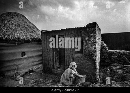 01 15 2009 Vintage Vieux noir et blanc photo de femme appliquant la boue et le plâtre de bouse de vache sur le mur de la maison Sri Dungargarh Bikaner District Rajasthan Inde Banque D'Images