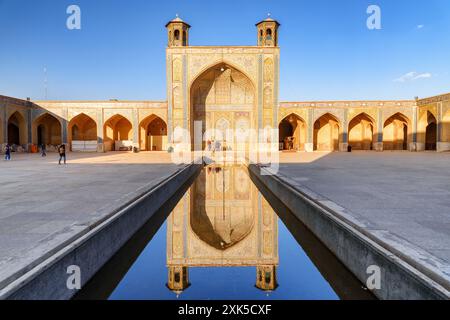 Vue imprenable sur le nord iwan reflété dans le réservoir d'eau au milieu de la cour de la mosquée Vakil à Shiraz, Iran. Banque D'Images