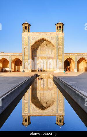 Vue imprenable sur le nord iwan reflété dans le réservoir d'eau au milieu de la cour de la mosquée Vakil à Shiraz, Iran. Banque D'Images