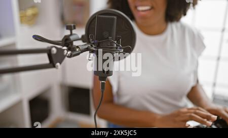 Femme afro-américaine chantant dans un studio de musique Banque D'Images