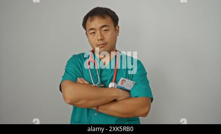 Jeune médecin chinois aux maquillages verts avec un stéthoscope, isolé sur fond blanc, croisant les bras en toute confiance. Banque D'Images