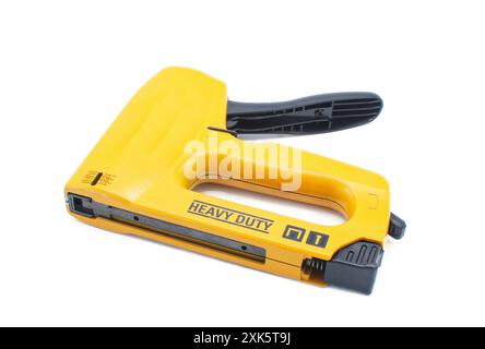 Agrafeuse professionnelle robuste ou pistolet à agrafes pour bois, sellerie, tapis, clôture métallique isolé sur fond blanc couleur jaune orange avec noir R Banque D'Images