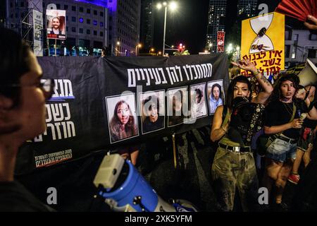 Les manifestants se rassemblent et chantent autour d'une pancarte avec les photos des soldats israéliens Liri Elbag, Karina Ariev, Agam Berger, Daniela Gilboa et Naama Levi - prises en otage par le Hamas le 7 octobre depuis la base militaire de Nahal Oz. Des dizaines de milliers de plus de 100 000 Israéliens ont manifesté à Kaplan avec les familles des otages contre le premier ministre Benjamin Netanyahu, exigeant un accord immédiat sur les otages et un cessez-le-feu - un jour avant le départ de Netanyahu pour parler devant le congrès américain à Washington. Tel Aviv, Israël. 20 juillet 2024. (Matan Golan/Sipa USA). Banque D'Images