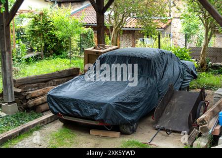 Voiture couverte garée sous pergola en bois dans le jardin à la française Banque D'Images