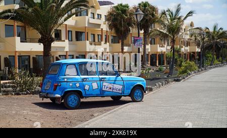 Voiture Renault classique conduite le long de la promenade du front de mer de Playa Blanca Banque D'Images