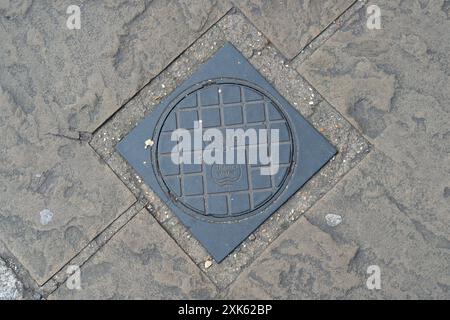 Eton, Royaume-Uni. 21 juillet 2024. Un couvercle de compteur d'eau de la Tamise à Eton, Windsor, Berkshire. Les poursuites engagées contre Thames Water par l'Agence de l'environnement pour des incidents de pollution ont abouti à des amendes de 35 millions de livres sterling entre 2017 et 2023. Le projet de loi sur l’eau (mesures spéciales) a été annoncé dans le discours du roi cette semaine. L'objectif du projet de loi, s'il est adopté, serait de renforcer les régulateurs de l'eau en donnant de nouveaux pouvoirs pour interdire le paiement de primes aux dirigeants des compagnies d'eau en cas de violation des normes environnementales. Les dirigeants des compagnies d'eau pourraient également faire l'objet de sanctions pénales. Crédit : Maureen McLean/Alamy Banque D'Images