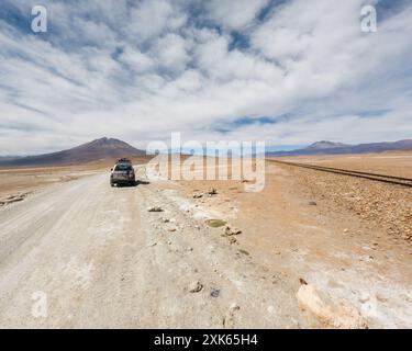 Route du désert courbant à travers un paysage sablonneux sous un ciel bleu clair. Voyage en plein air et concept d'aventure. Vue aérienne de la route du désert. Banque D'Images