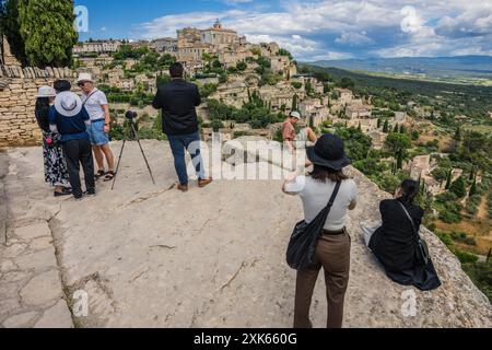 Touristes capturant des images d'un point de vue surplombant le village perché de Gordes, Vaucluse, Provence, France. Banque D'Images