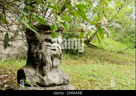 Statue en pierre de Pan dans le bosquet sacré de Bomarzo entouré d'une végétation luxuriante. Cette figure mythologique, également connue sous le nom de faun, ajoute une mystique et une Banque D'Images