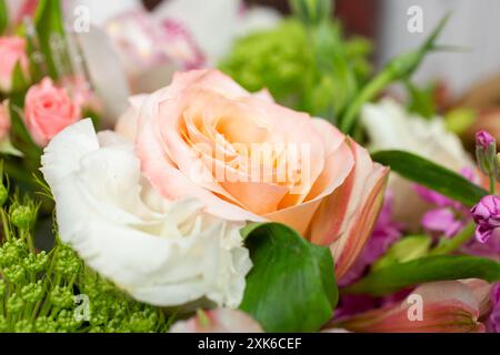 Une vue rapprochée d'un bouquet floral, avec une rose couleur pêche. Banque D'Images