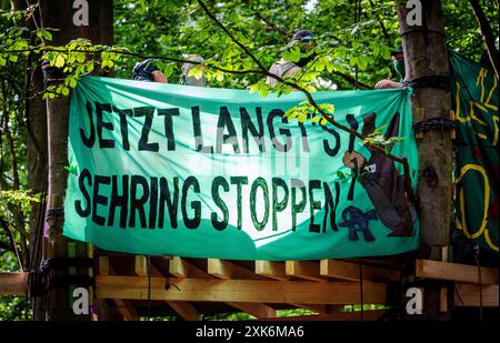 Langen, Allemagne. 21 juillet 2024. En signe de protestation contre les autorisations attendues pour l'extraction de gravier, des militants ont érigé une plate-forme dans la forêt et accroché une banderole avec le slogan "Jetzt Langt's Sehring stoppen" (arrêtez Langt's Sehring Now). La société Sehring Sand & Kies GmbH & Co. KG carrières de gravier et de sable à Waldsee. La police a parlé d'une vingtaine de manifestants, un porte-parole des militants de deux douzaines. Crédit : Andreas Arnold/dpa/Alamy Live News Banque D'Images