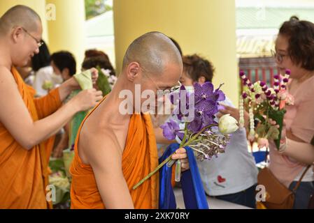 Bangkok, Thaïlande. 13 juillet 2024. Les bouddhistes offrent des fleurs aux moines. A l'occasion du Carême bouddhiste, au Wat Debsirindrawas Ratchaworawihan à Bangkok, Thaïlande, le 21 juillet 2024. Représente le point de départ du Carême bouddhiste est le moment où les moines sont tenus de rester dans les temples pendant la saison des pluies pour étudier le dhamma et pratiquer la méditation pendant une période de trois mois. (Photo de Teera Noisakran/Sipa USA) crédit : Sipa USA/Alamy Live News Banque D'Images