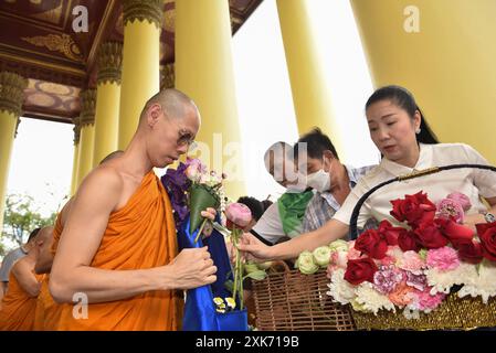 Bangkok, Thaïlande. 13 juillet 2024. Les bouddhistes offrent des fleurs aux moines. A l'occasion du Carême bouddhiste, au Wat Debsirindrawas Ratchaworawihan à Bangkok, Thaïlande, le 21 juillet 2024. Représente le point de départ du Carême bouddhiste est le moment où les moines sont tenus de rester dans les temples pendant la saison des pluies pour étudier le dhamma et pratiquer la méditation pendant une période de trois mois. (Photo de Teera Noisakran/Sipa USA) crédit : Sipa USA/Alamy Live News Banque D'Images