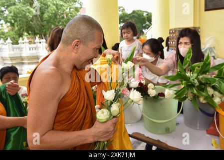 Bangkok, Thaïlande. 13 juillet 2024. Les bouddhistes offrent des fleurs aux moines. A l'occasion du Carême bouddhiste, au Wat Debsirindrawas Ratchaworawihan à Bangkok, Thaïlande, le 21 juillet 2024. Représente le point de départ du Carême bouddhiste est le moment où les moines sont tenus de rester dans les temples pendant la saison des pluies pour étudier le dhamma et pratiquer la méditation pendant une période de trois mois. (Photo de Teera Noisakran/Sipa USA) crédit : Sipa USA/Alamy Live News Banque D'Images