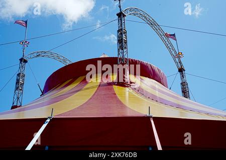 Bridgend, pays de Galles - 7 juillet 2024 : un grand cirque aux couleurs vives, en jaune et rouge. Les cordes de guidage ou de haubanage augmentent la stabilité structurelle o Banque D'Images