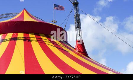 Bridgend, pays de Galles - 7 juillet 2024 : un grand cirque aux couleurs vives, en jaune et rouge. Les cordes de guidage ou de haubanage augmentent la stabilité structurelle o Banque D'Images