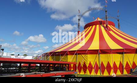 Bridgend, pays de Galles - 7 juillet 2024 : un grand cirque aux couleurs vives, en jaune et rouge. Les cordes de guidage ou de haubanage augmentent la stabilité structurelle o Banque D'Images