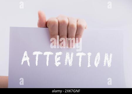 Main tenant un livre blanc avec attention une formulation sur white Banque D'Images