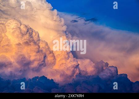 Grands nuages de calvus cumulonimbus éclairés par le coucher du soleil d'été Banque D'Images