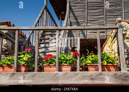 L'escalier en bois de la vieille maison dans le style balkanique avec le géranium rouge sur elle le long de la main courante, ville de Sozopol en Bulgarie Banque D'Images