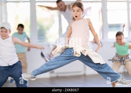 Preteen girl en mi-saut pendant le cours de danse hip hop Banque D'Images