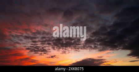 Les nuages du coucher du soleil se rassemblent. Ciel panoramique de lever ou de coucher de soleil avec des nuages. Coucher de soleil ciel sur crépuscule dans la soirée avec coucher de soleil. Nuage nature ciel Banque D'Images