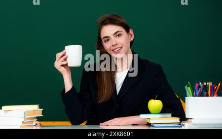 Le nouveau professeur vérifie les devoirs. Étudiante attirante ou nouvelle enseignante. Apprentissage de la langue et concept d'éducation. Étudiant avec tasse à boire Banque D'Images