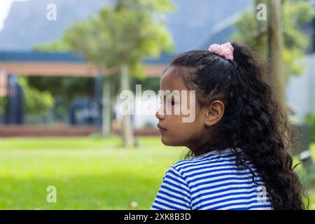 Dans un cadre scolaire, une jeune fille hispanique regarde soigneusement, copie l'espace Banque D'Images