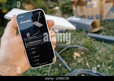 Francfort, Allemagne - 15 juin 2023 : recherche de messages dans l'application Starlink sur un iPhone d'Apple tout en configurant une nouvelle antenne Internet satellite Starlink, mettant en évidence l'intégration de la technologie et de la connectivité Banque D'Images