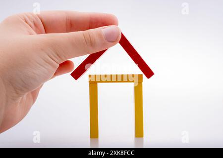 Hand holding pièces domino formant une forme de maison Banque D'Images