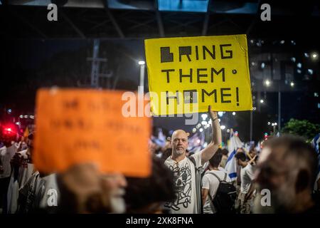 Tel Aviv, Israël. 20 juillet 2024. Un manifestant tient une pancarte pendant la manifestation. Des manifestants antigouvernementaux se sont rassemblés dans des villes à travers Israël pour appeler le premier ministre Benjamin Netanyahu à ne pas partir pour une visite prévue à Washington le lendemain tant qu'il n'a pas signé un accord avec le Hamas pour faciliter le retour de l'otage de Gaza. Des désaccords subsistent entre Netanyahu et l'équipe de négociation d'Israël au sujet de l'accord d'otages avant la visite prévue du premier ministre à Washington et son discours au Congrès. Crédit : SOPA images Limited/Alamy Live News Banque D'Images