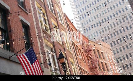 Architecture du bâtiment de New York. Extérieur de maison résidentielle. Immobilier, drapeau USA. Façade typique en briques rouges. Quartier financier du centre-ville de Manhattan, Stone Street, FIDI. Echelle d'évacuation en cas d'incendie Banque D'Images