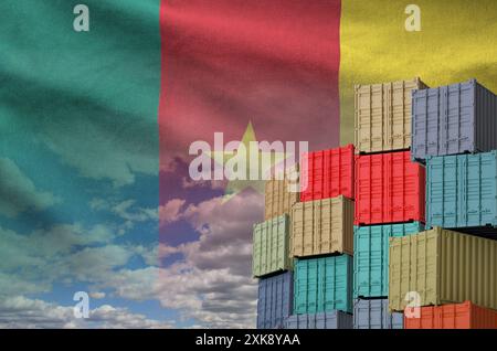 Drapeau du Cameroun et grande pile de conteneurs de fret maritime dans les docks avec fond de ciel de près Banque D'Images