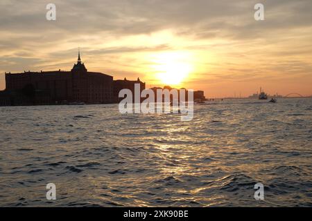 Profiter du coucher du soleil depuis le front de mer à Dorsoduro, vue sur le canal à une silhouette de Hilton Molino Stucky, Venise, Italie Banque D'Images