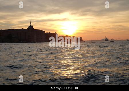 Profiter du coucher du soleil depuis le front de mer à Dorsoduro, vue sur le canal à une silhouette de Hilton Molino Stucky, Venise, Italie Banque D'Images