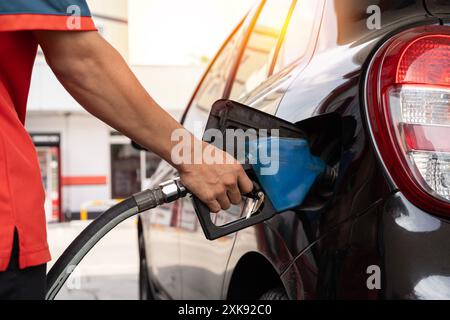 Ravitaillement en carburant à la station-service. Pompe à carburant à la station. Ravitaillement de la voiture à la pompe à essence d'une station-service. Homme conducteur main remplissage et pompage d'essence oi Banque D'Images