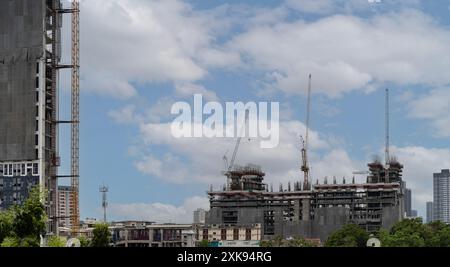 Grue et bâtiment de chantier de construction contre le ciel bleu fond d'architecture moderne de nombreux bâtiments de grande hauteur en construction et grues sous le Banque D'Images