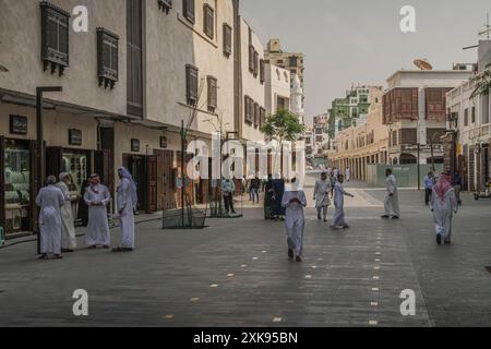 Le peuple saoudien local dans les rues du centre-ville de Djeddah, une grande ville dans l'ouest de l'Arabie Saoudite, à l'architecture arabe moderne et ancienne. Banque D'Images