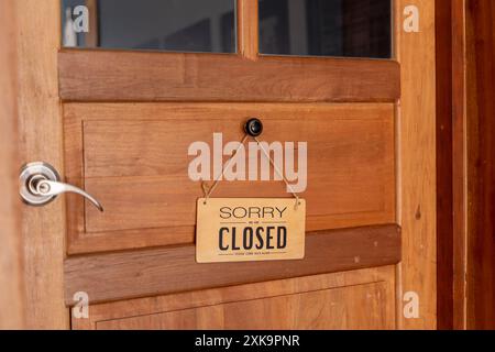 Message sur un panneau en bois Désolé, nous sommes fermés dans les cafés et restaurants. Panneau d'affichage sur la porte en bois à l'entrée du magasin Banque D'Images