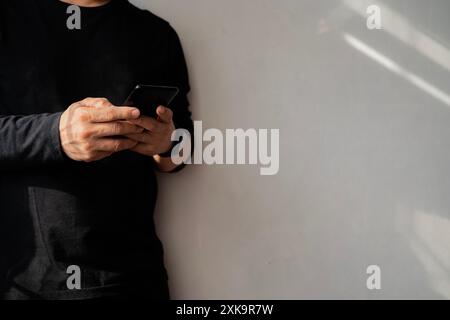 Homme d'affaires tenant smartphone et pointant avec un doigt sur un message important, dans des vêtements décontractés présentant des informations importantes messieurs montrant Banque D'Images