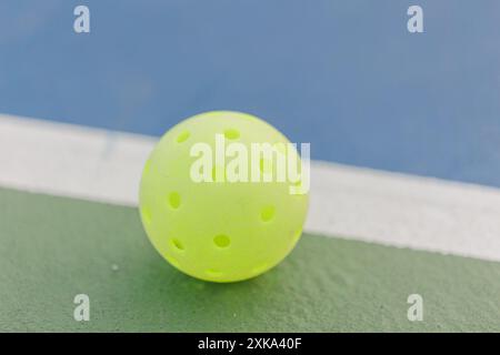 Pickleball vert néon sur terrain vert avec ligne blanche, gros plan. Banque D'Images