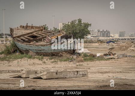 Le vieux bateau de pêche abandonné sur la terre ferme à Djeddah, en Arabie saoudite, dans la zone pauvre et sous-développée. Banque D'Images