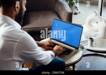 Homme avec ordinateur portable montrant l'écran bleu de la mort ou BSOD sur l'écran du moniteur. Système d'exploitation Microsoft Windows 10 défectueux. Rosario, Argentine - 19 juillet Banque D'Images