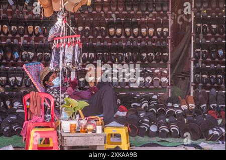 Phnom Penh, Cambodge. Vendeur de chaussures, portant un masque facial de protection, attend les clients pendant la pandémie COVID-19. Juin 2021. © Kraig Lieb Banque D'Images