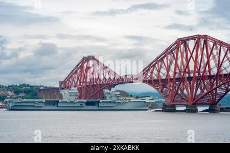 South Queensferry, Écosse, Royaume-Uni. 22 juillet 2024. Le porte-avions de la Royal Navy HMS Queen Elizabeth quitte le chantier naval de Rosyth et navigue sous le Forth Bridge à marée basse après l'achèvement des réparations. Iain Masterton/Alamy Live News Banque D'Images