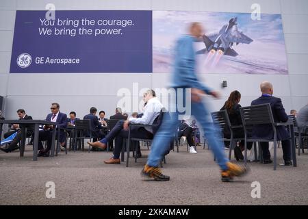 Les gens sont assis devant un panneau pour GE Aerospace au salon aéronautique international de Farnborough dans le Hampshire. Date de la photo : lundi 22 juillet 2024. Banque D'Images